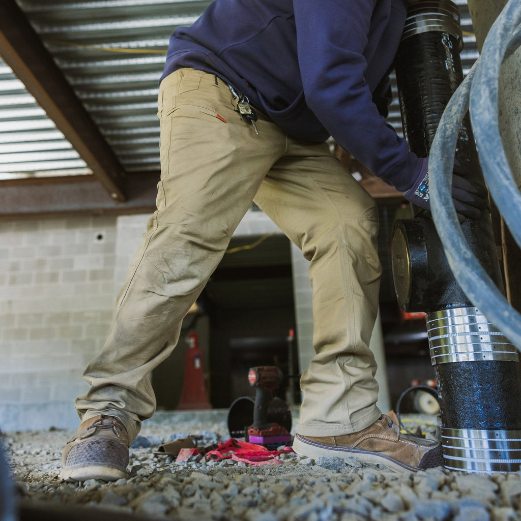 Man on jobsite wearing the BRUNT water resistant stretch torra work pant in khaki