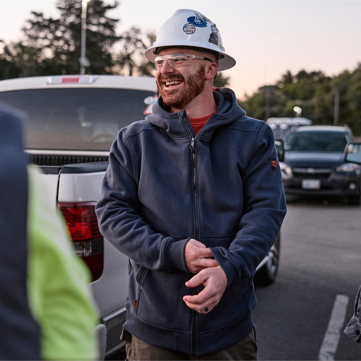 Man on jobsite wearing BRUNT water resistant full zip shevlin work hoodie in navy blue