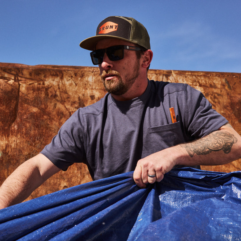 Man wearing BRUNT high quality short sleeve pocket tee in navy outside on jobsite