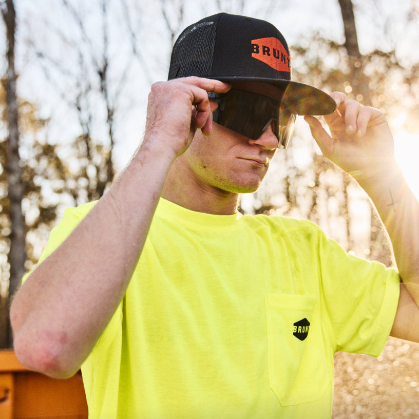 Man on jobsite wearing BRUNT future tech sunglasses in black