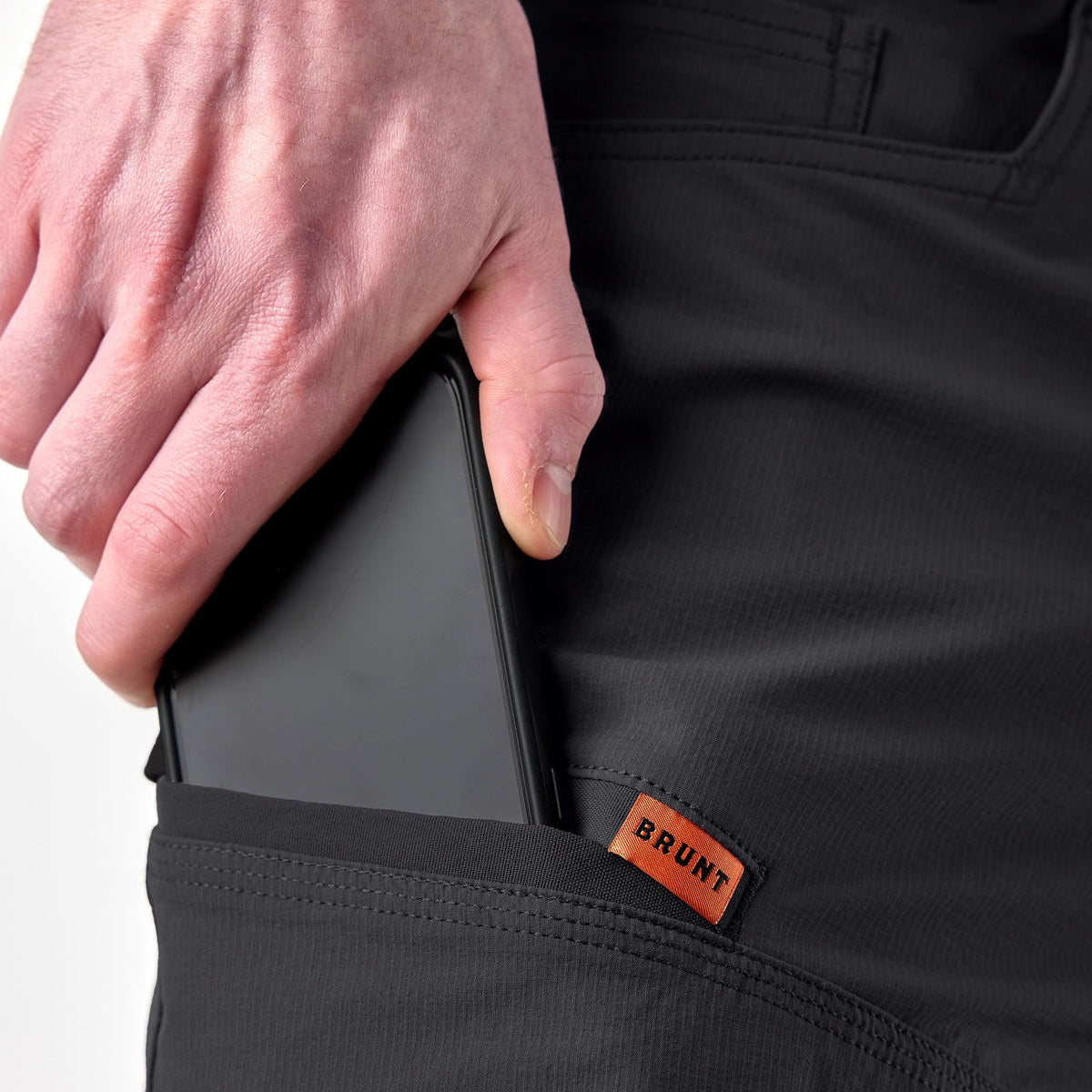Putting phone in cargo pocket of BRUNT water resistant durable breathable work pant in black