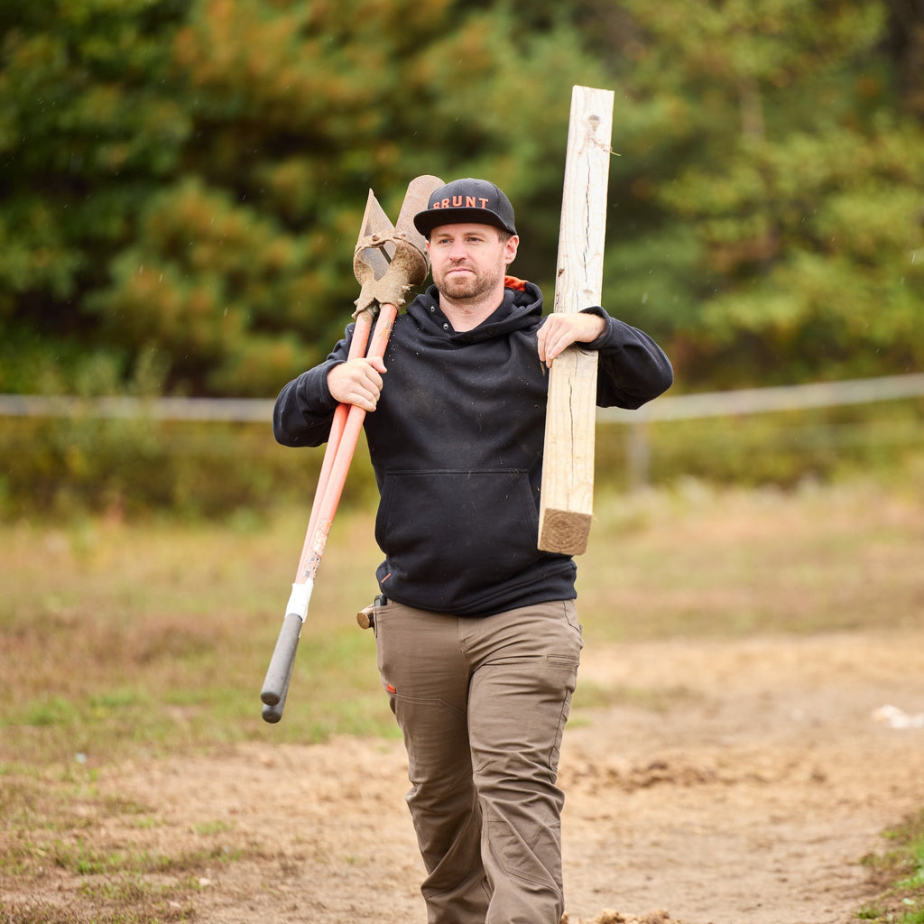 Man on jobsite wearing the BRUNT water resistant shevlin work hoodie in black