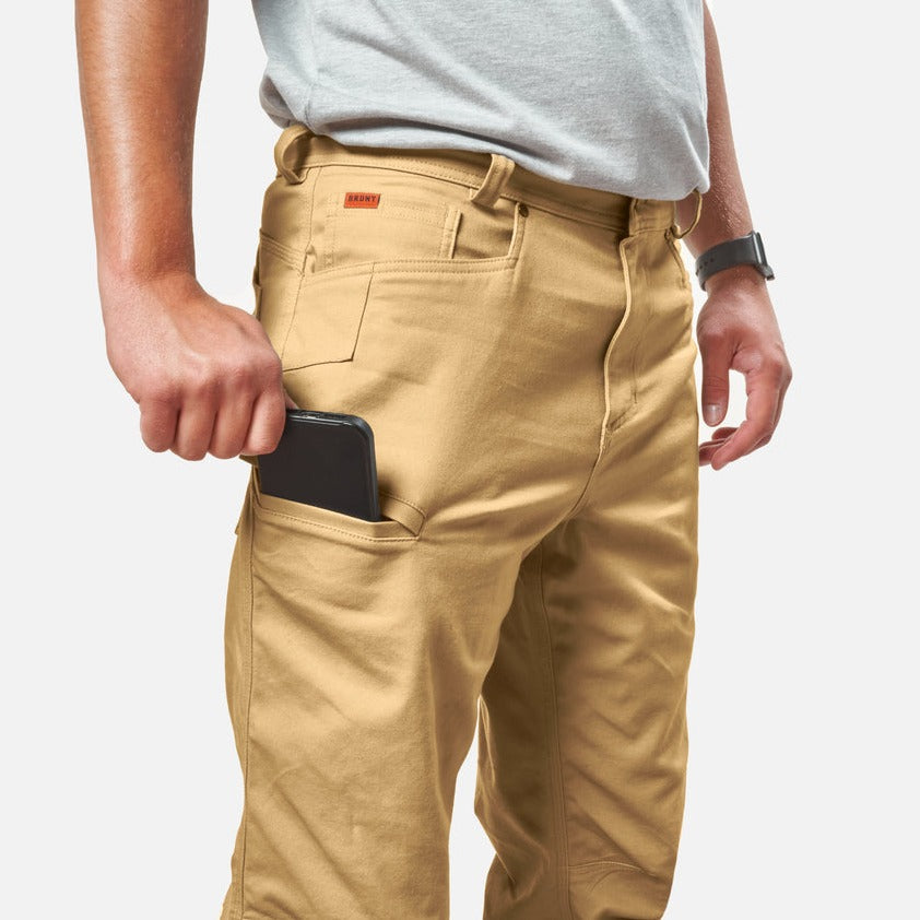 View 2 putting phone in tech pocket of BRUNT water resistant stretch torra work pant in tan * 1