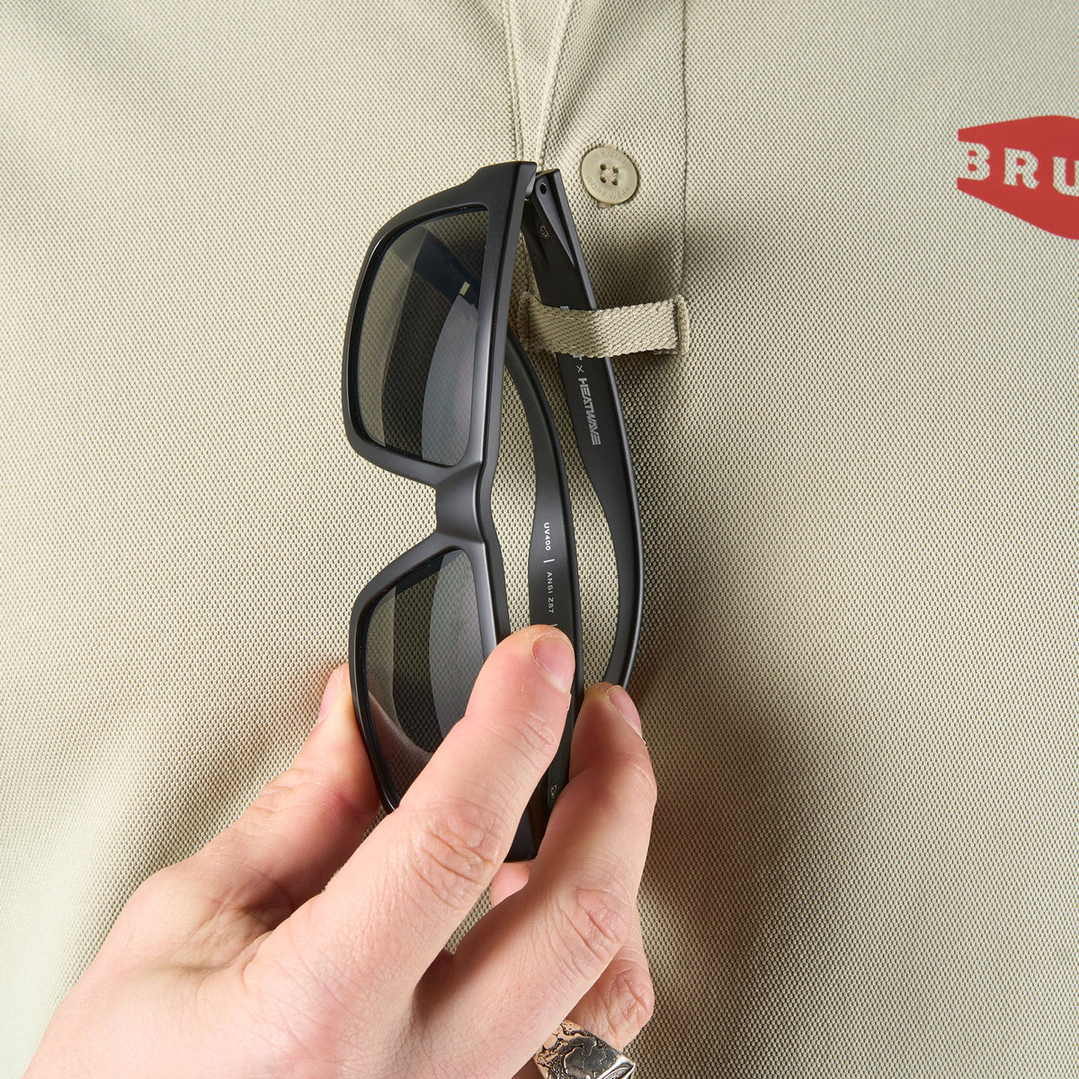Close up of chest loop for sunglasses of the BRUNT lightweight breathable polo with UPF protection in khaki * 2