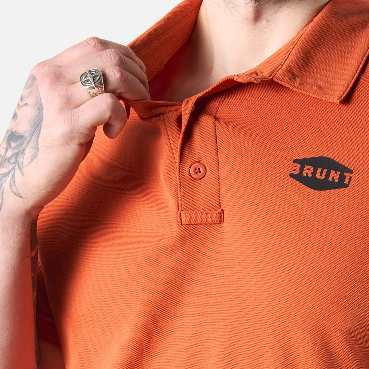 Close up of front collar of the BRUNT lightweight breathable polo with UPF protection in BRUNT orange * 4