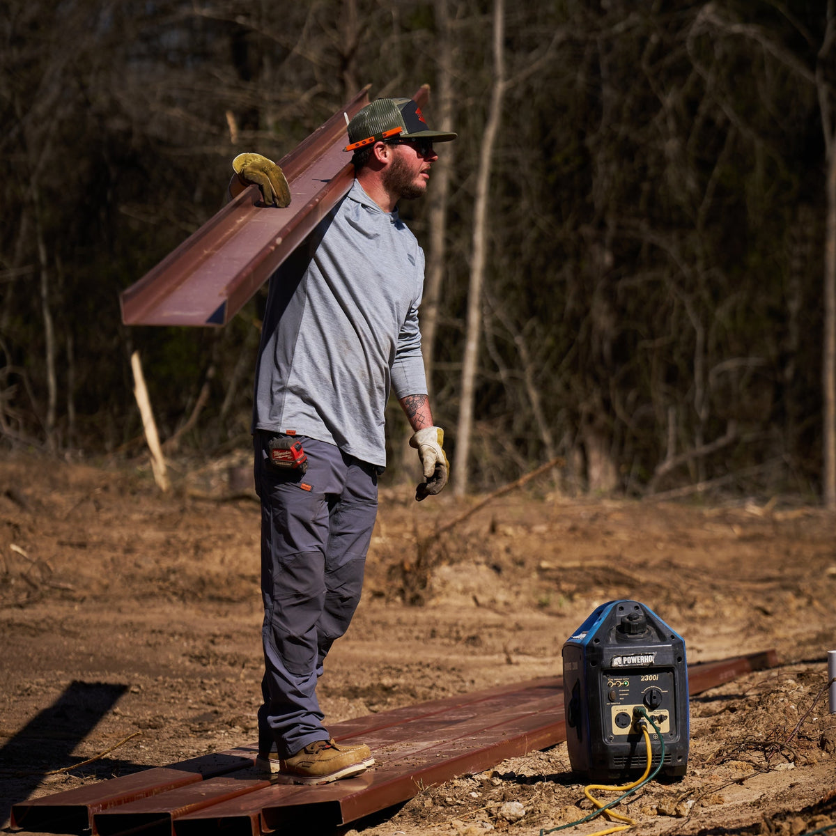 Man on jobsite wearing BRUNT water-resistant lightweight breathable costello work pant in charcoal