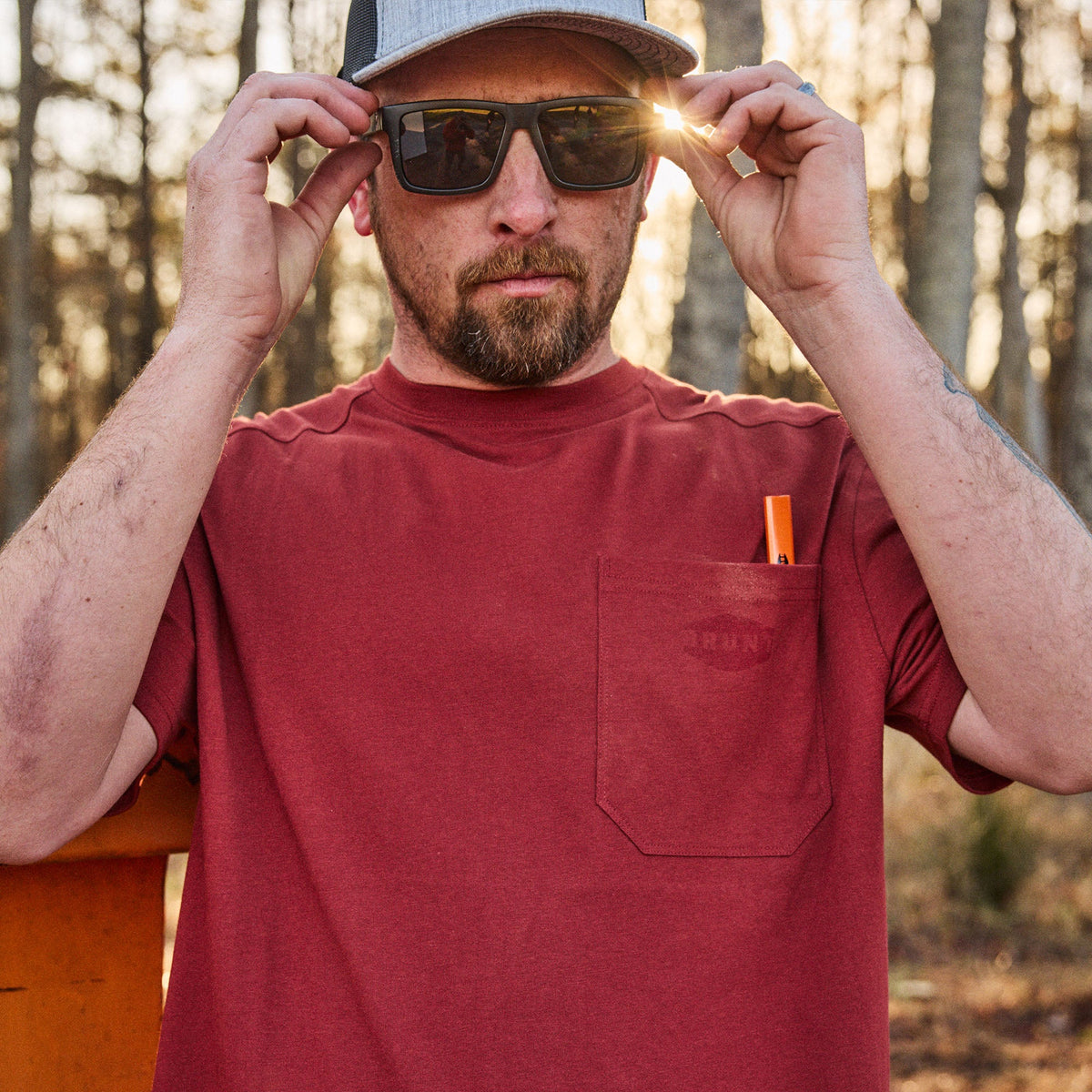 Man wearing BRUNT high quality short sleeve pocket tee in brick red outside on jobsite* 6