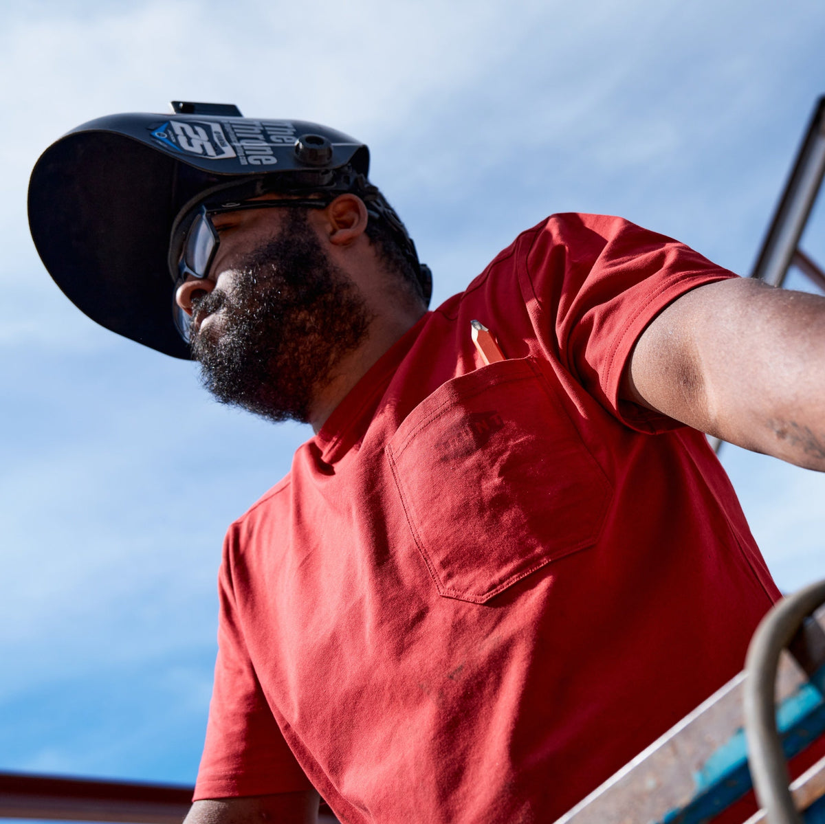 Man wearing BRUNT high quality short sleeve pocket tee in red outside on jobsite