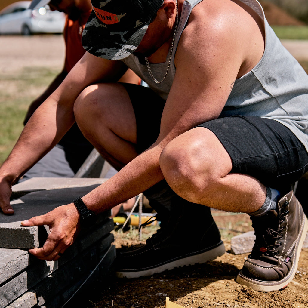 Man on jobsite wearing the BRUNT 9 inch water resistant stretch work short in charcoal