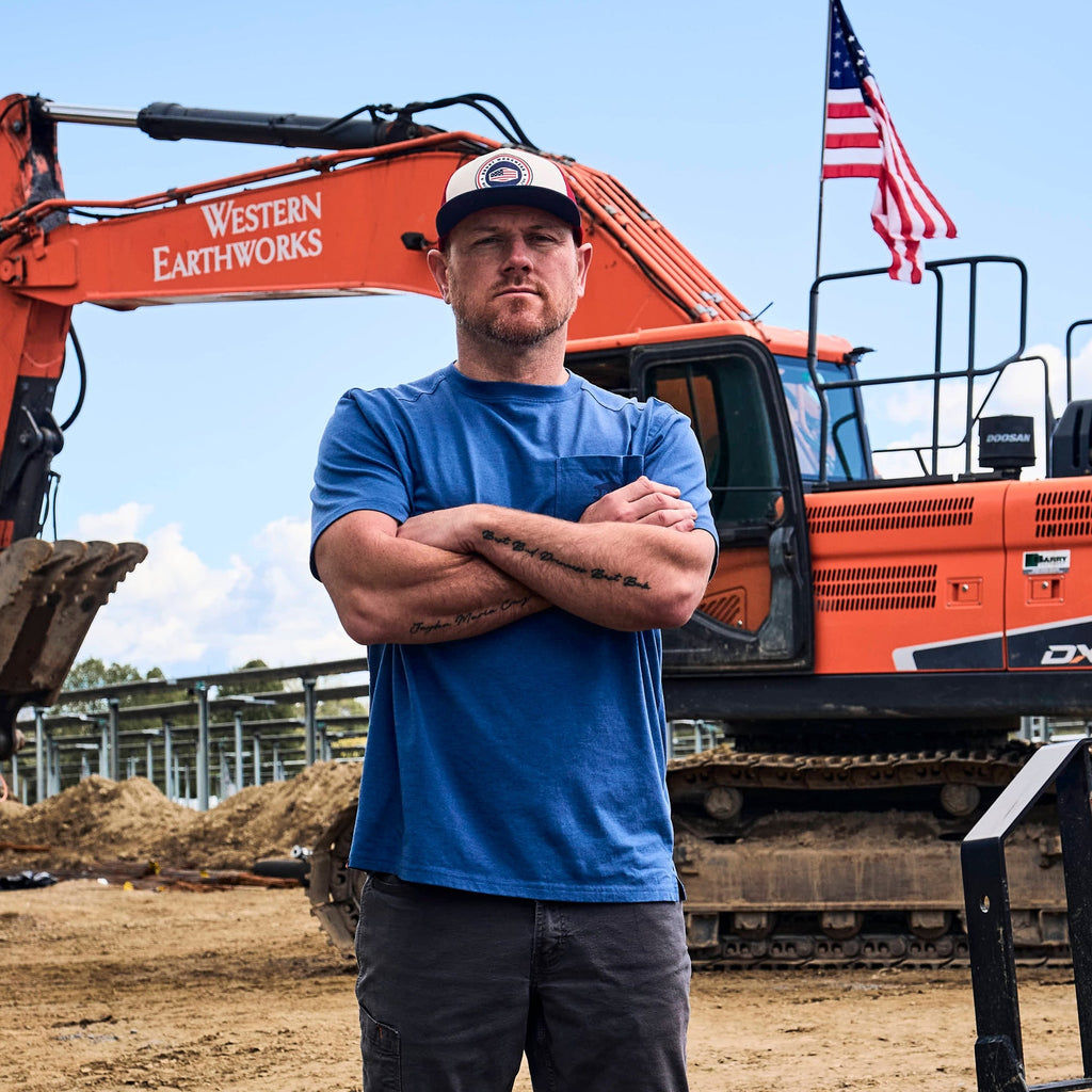 Man wearing BRUNT high quality short sleeve pocket tee in blue heather outside on jobsite