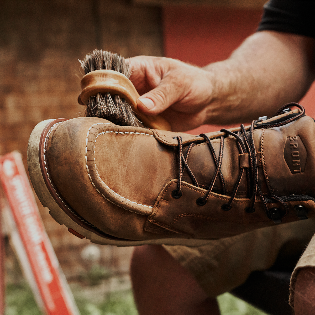 View 2 man applying BRUNT leather work boot conditioner with horse hair brush to BRUNT Marin work boots