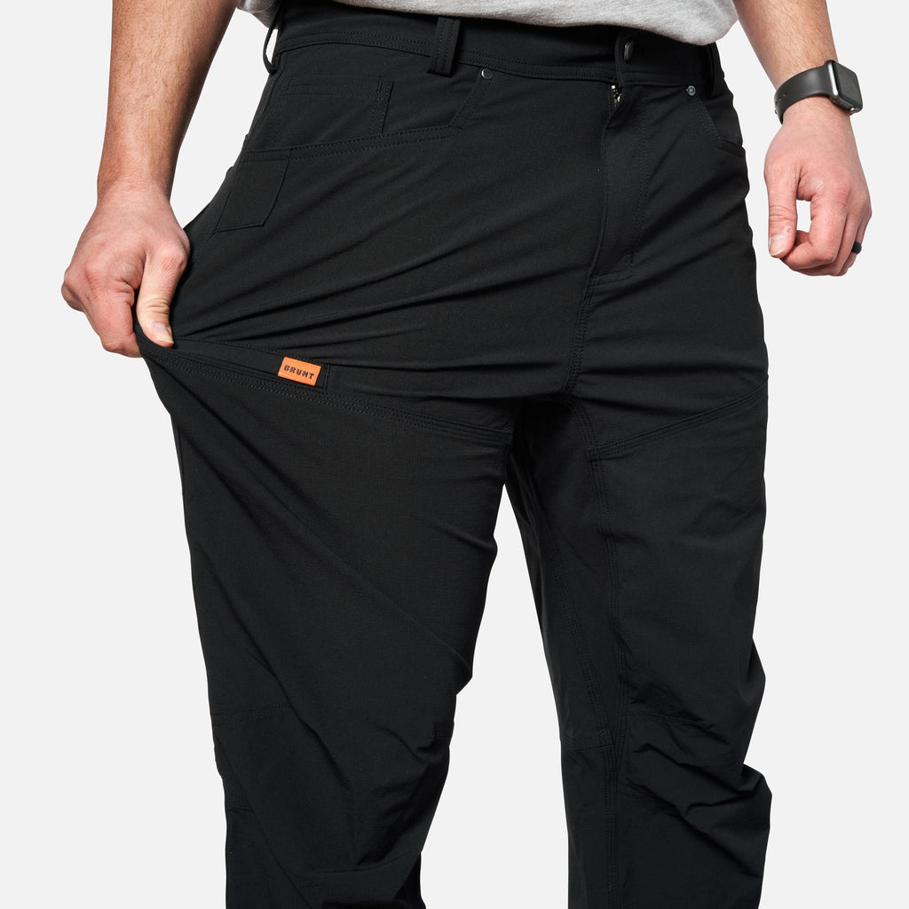 Putting phone in tech pocket of BRUNT water-resistant lightweight lined costello work pant in black