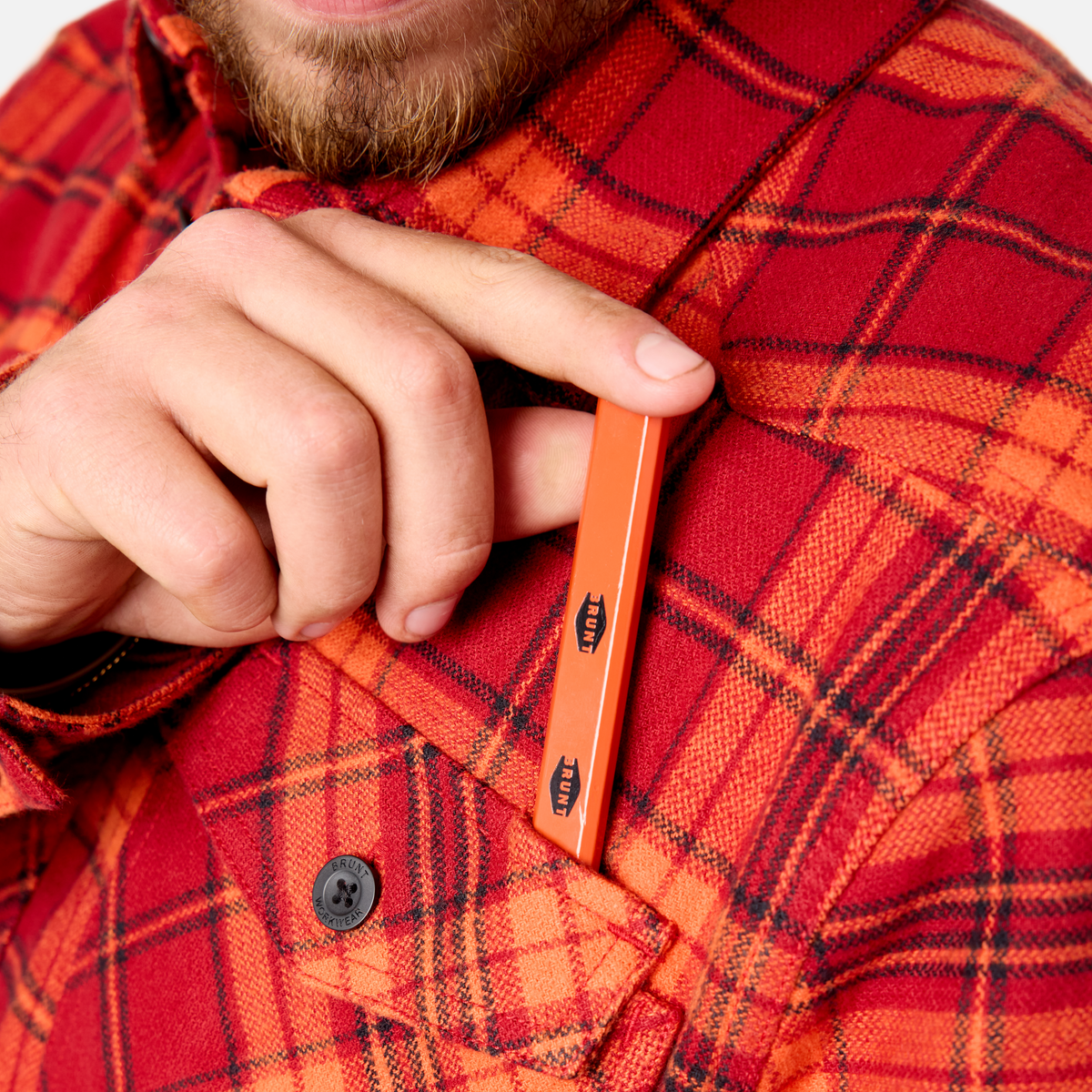 Front of chest pocket with pencil slot of the BRUNT heavy duty stretch work flannel in orange plaid * 1