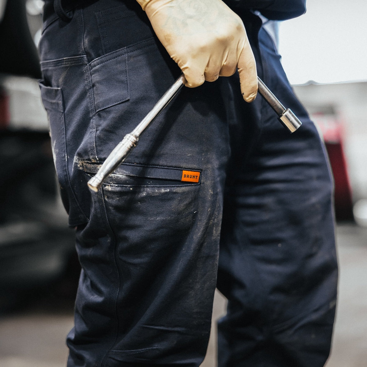 Man on jobsite wearing the BRUNT water resistant stretch torra work pant in dark navy