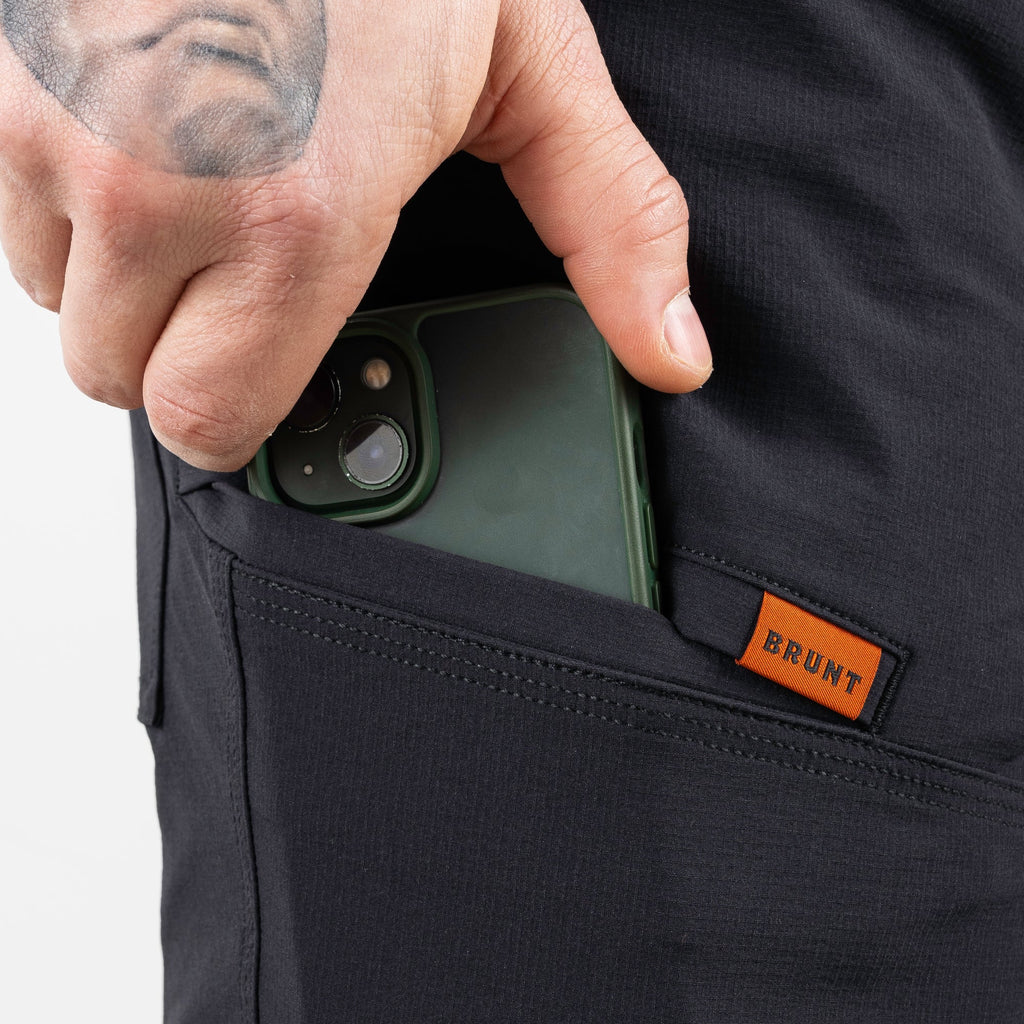 Putting phone in tech pocket of BRUNT 9 inch lightweight breathable costello work shorts in black