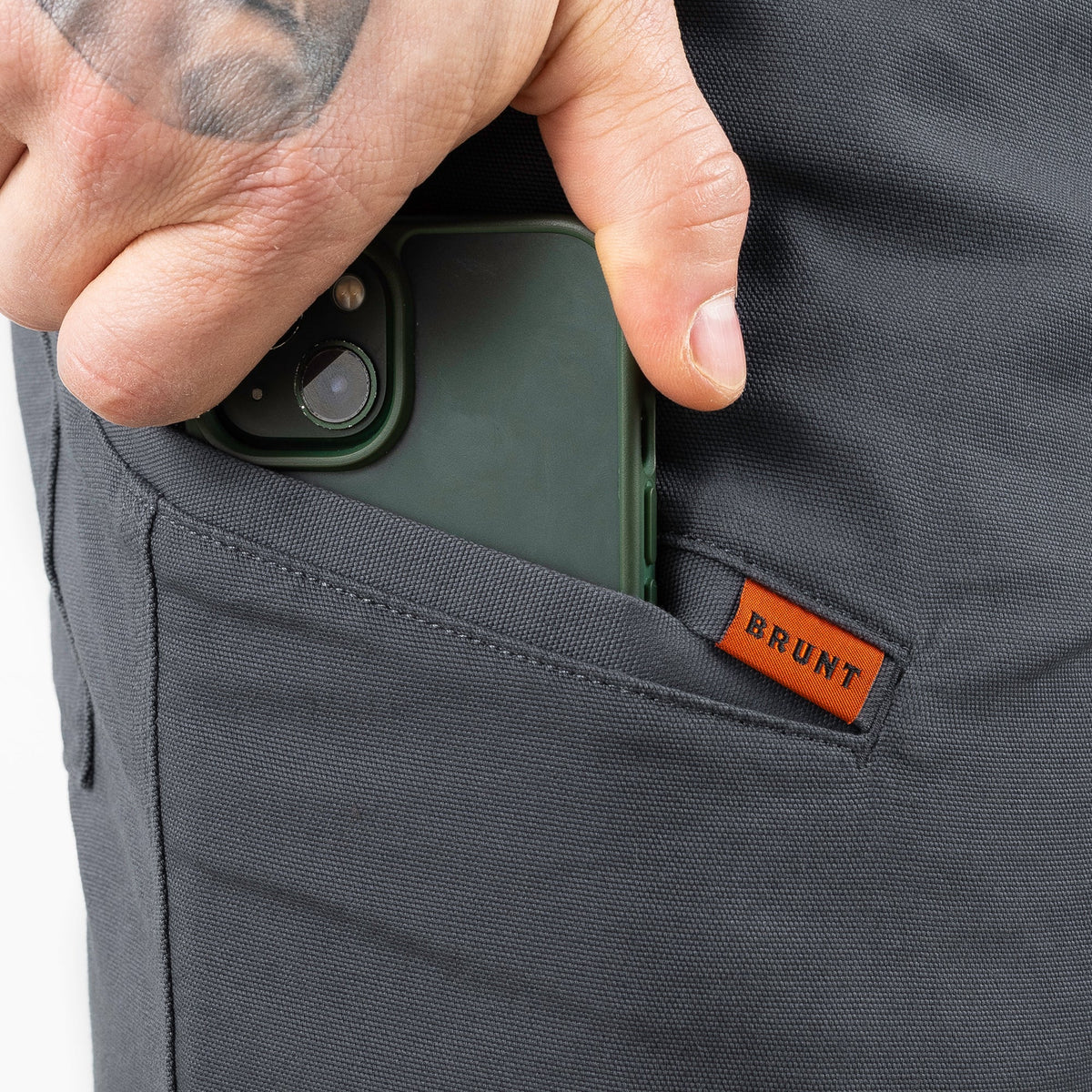 Putting phone in pocket of the BRUNT 9 inch water resistant stretch work short in charcoal