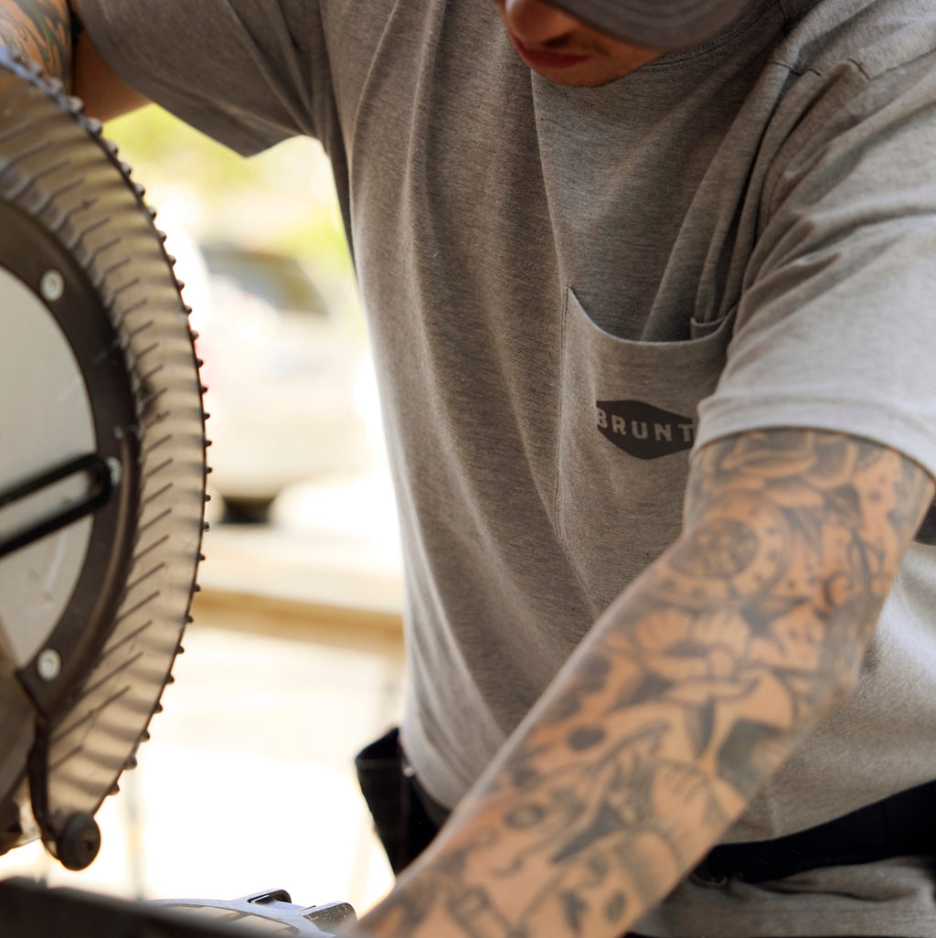 Man wearing BRUNT high quality short sleeve pocket tee in light grey heather using table saw on jobsite * 2