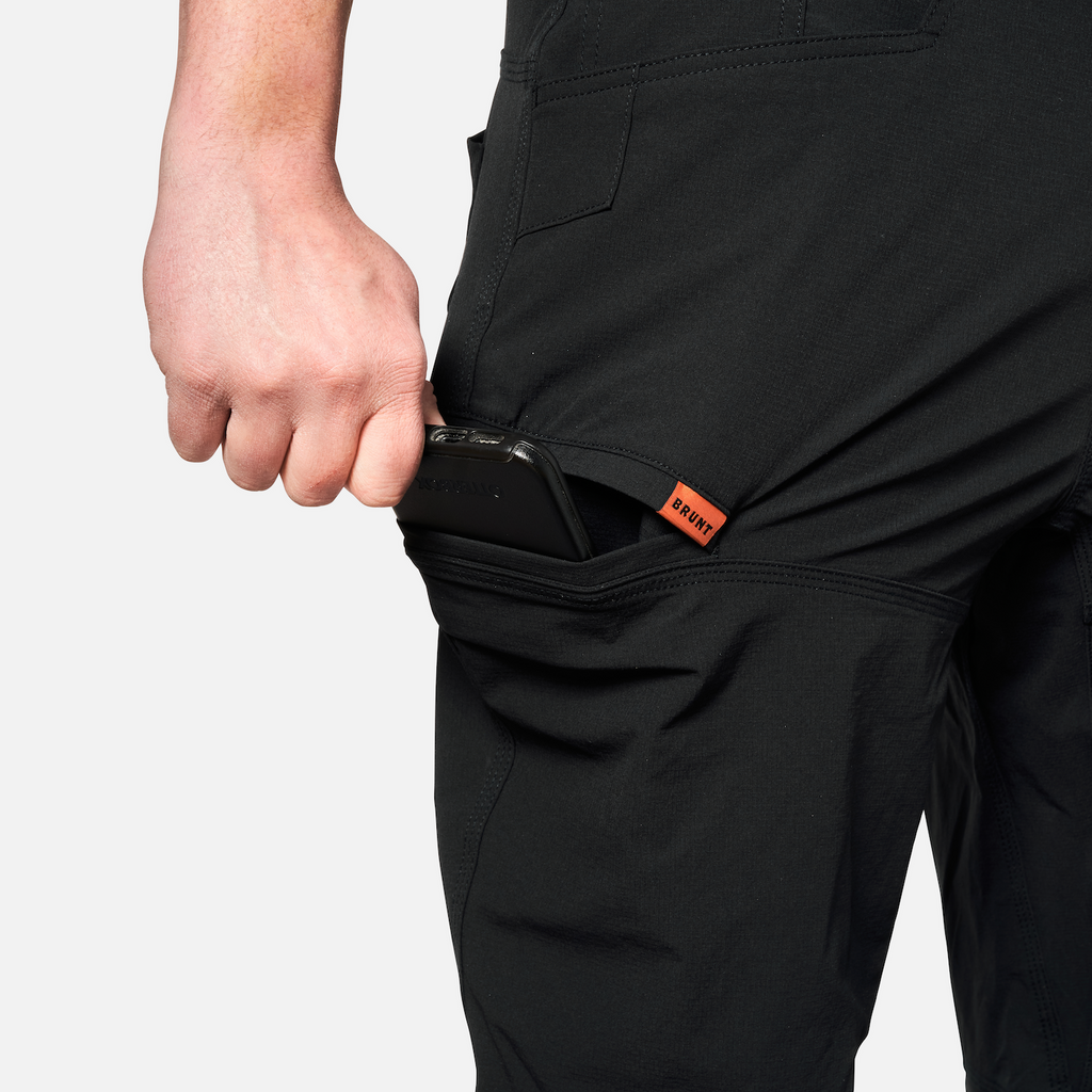 Putting phone in tech pocket of BRUNT water-resistant lightweight breathable costello work pant in black * 3