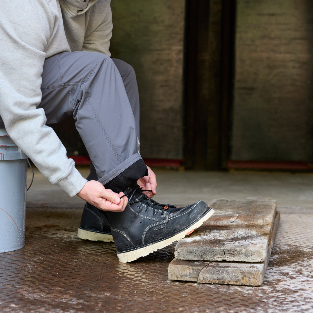 Man on jobsite wearign BRUNT water-resistant lightweight lined costello work pant in charcoal