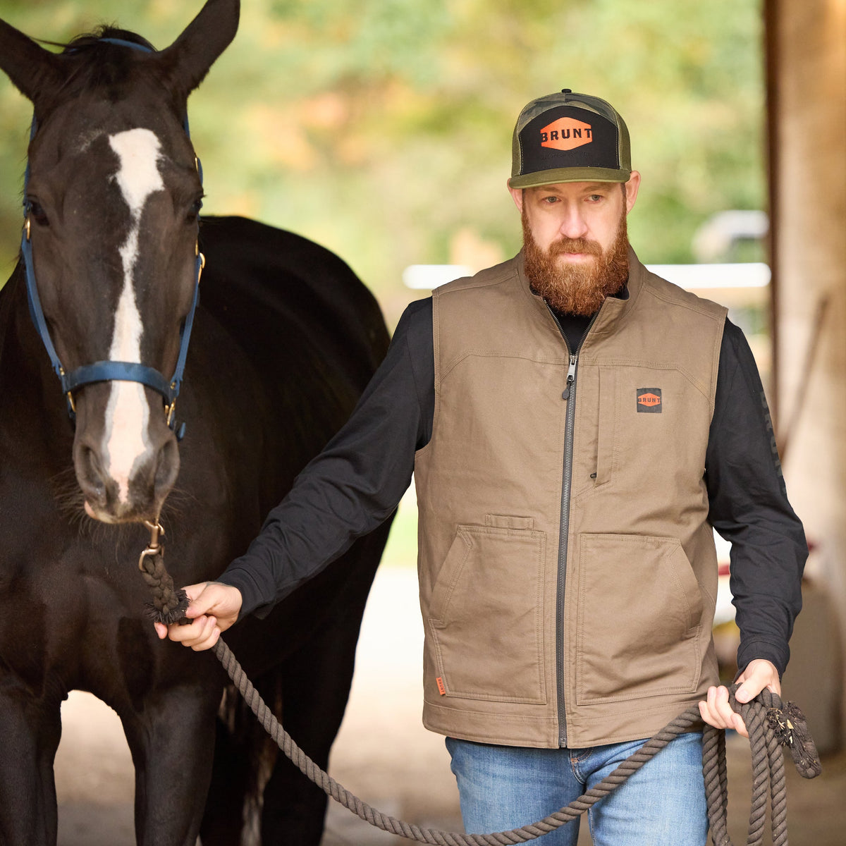 Man wearing BRUNT quilt stretch canvas work best in brown walking with horse * 2
