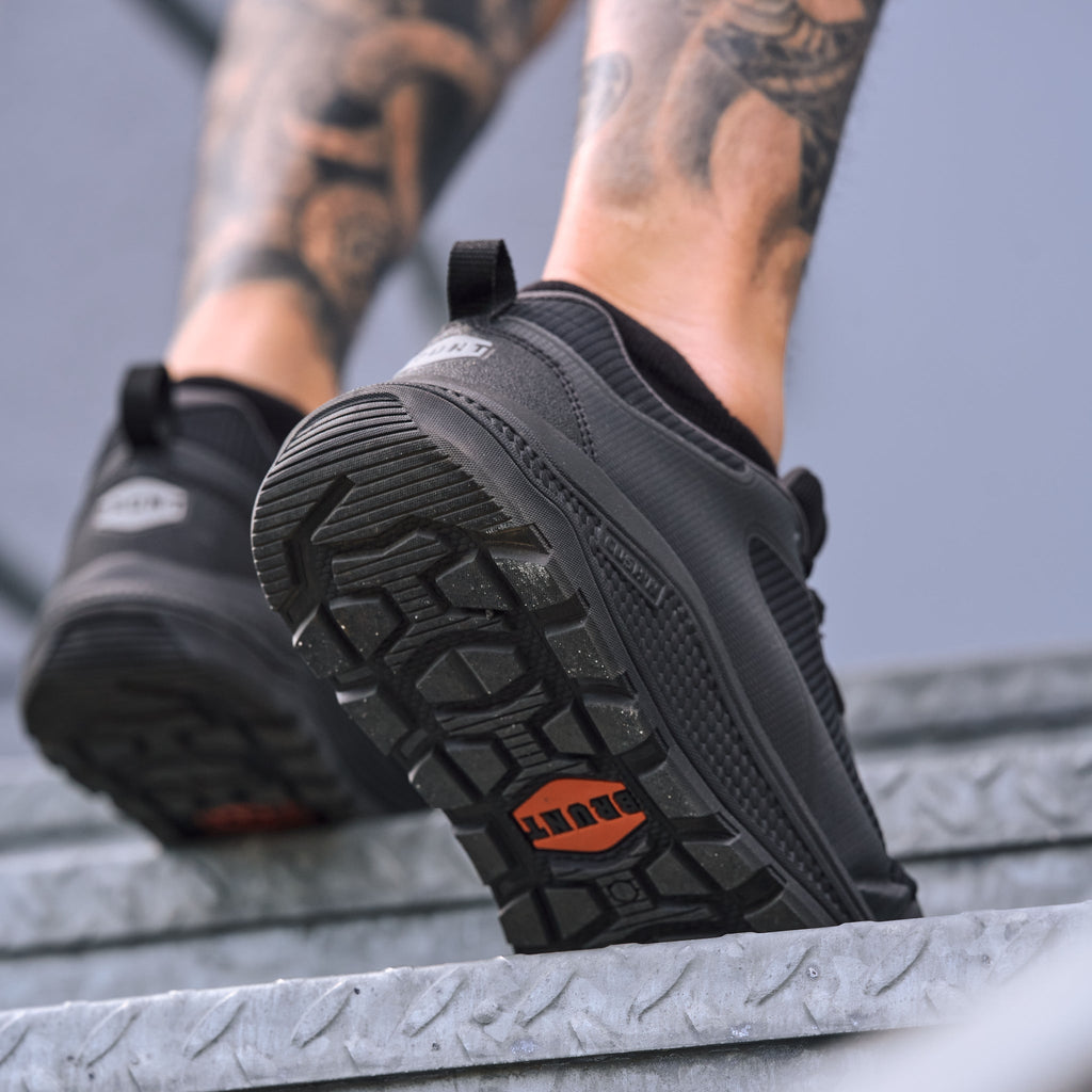 Man walking up stairs in BRUNT 4 inch lightweight comp toe work sneaker in black * 1