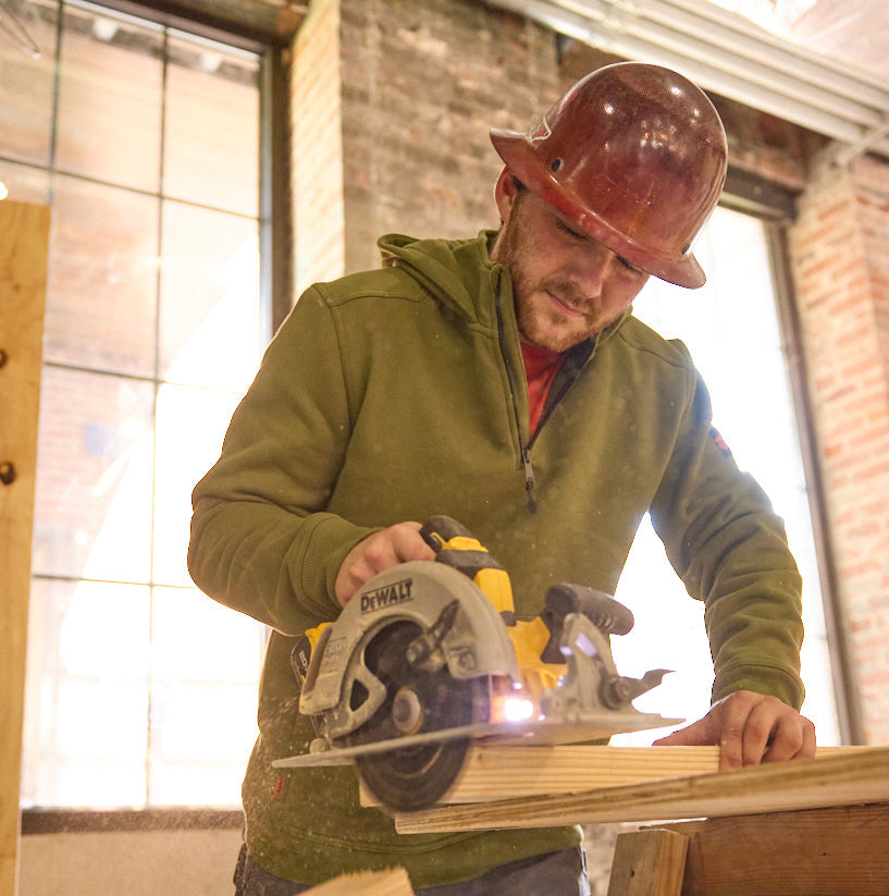 Man wearing BRUNT water resistant shevlin work quarter zip hoodie in hunter green using table saw on jobsite * 0