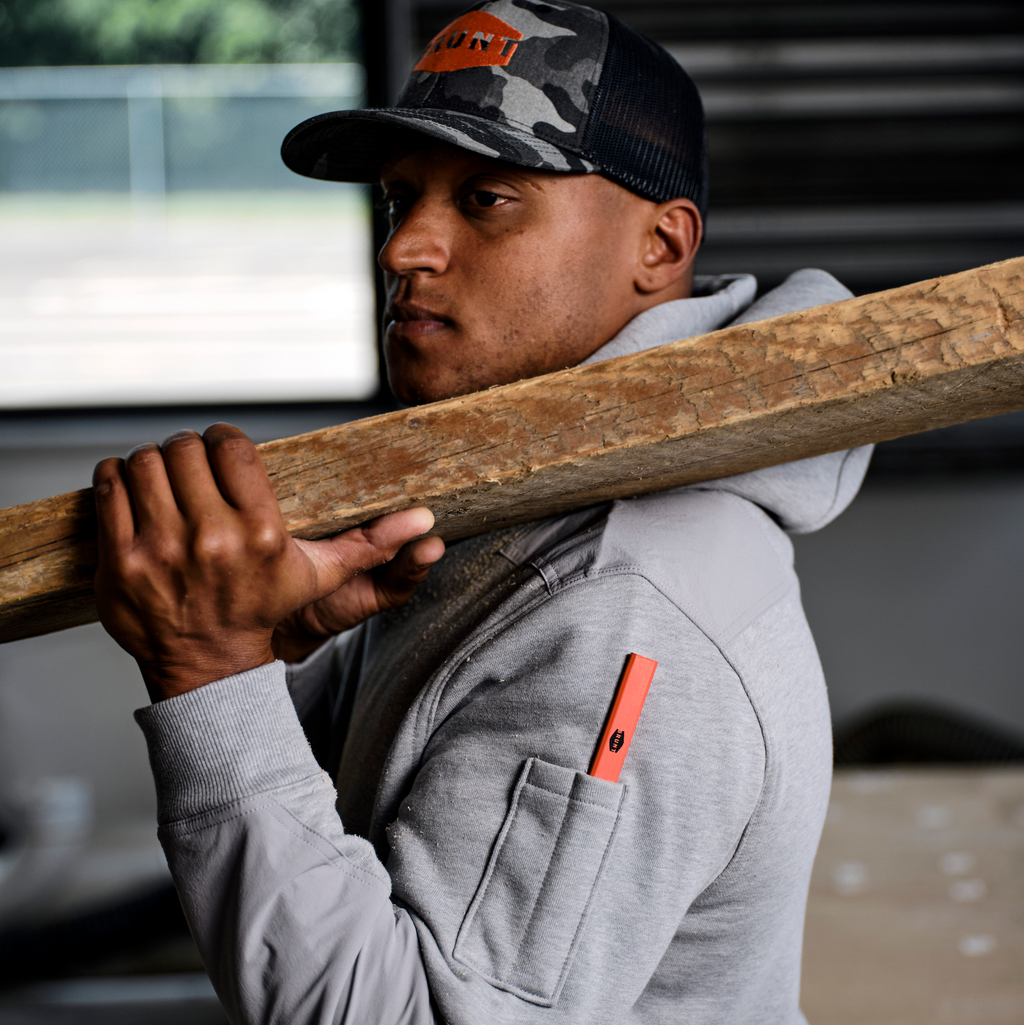 Left side of man wearing the BRUNT water resistant heavy duty shevlin work hoodie in grey heather with wood beam on shoulder * 0
