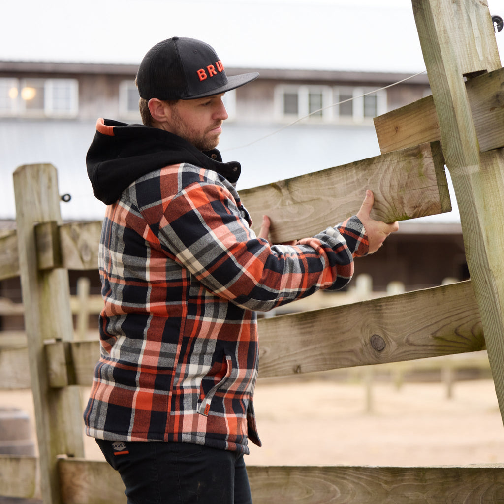 Man fixing fence in BRUNT quilted flannel work jacket in black orange plaid * 1
