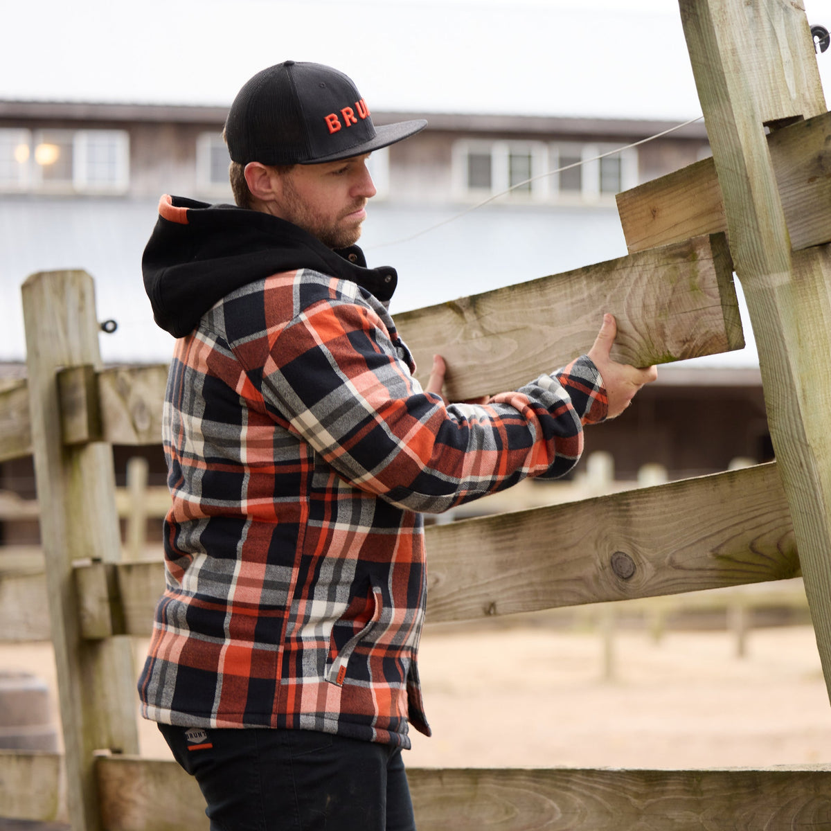 Man fixing fence in BRUNT quilted flannel work jacket in black orange plaid * 1