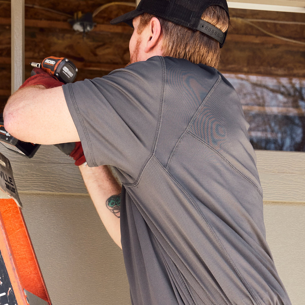 Man on jobsite wearing BRUNT lightweight breathable ventilated tech polo with UPF protection in carbon * 1